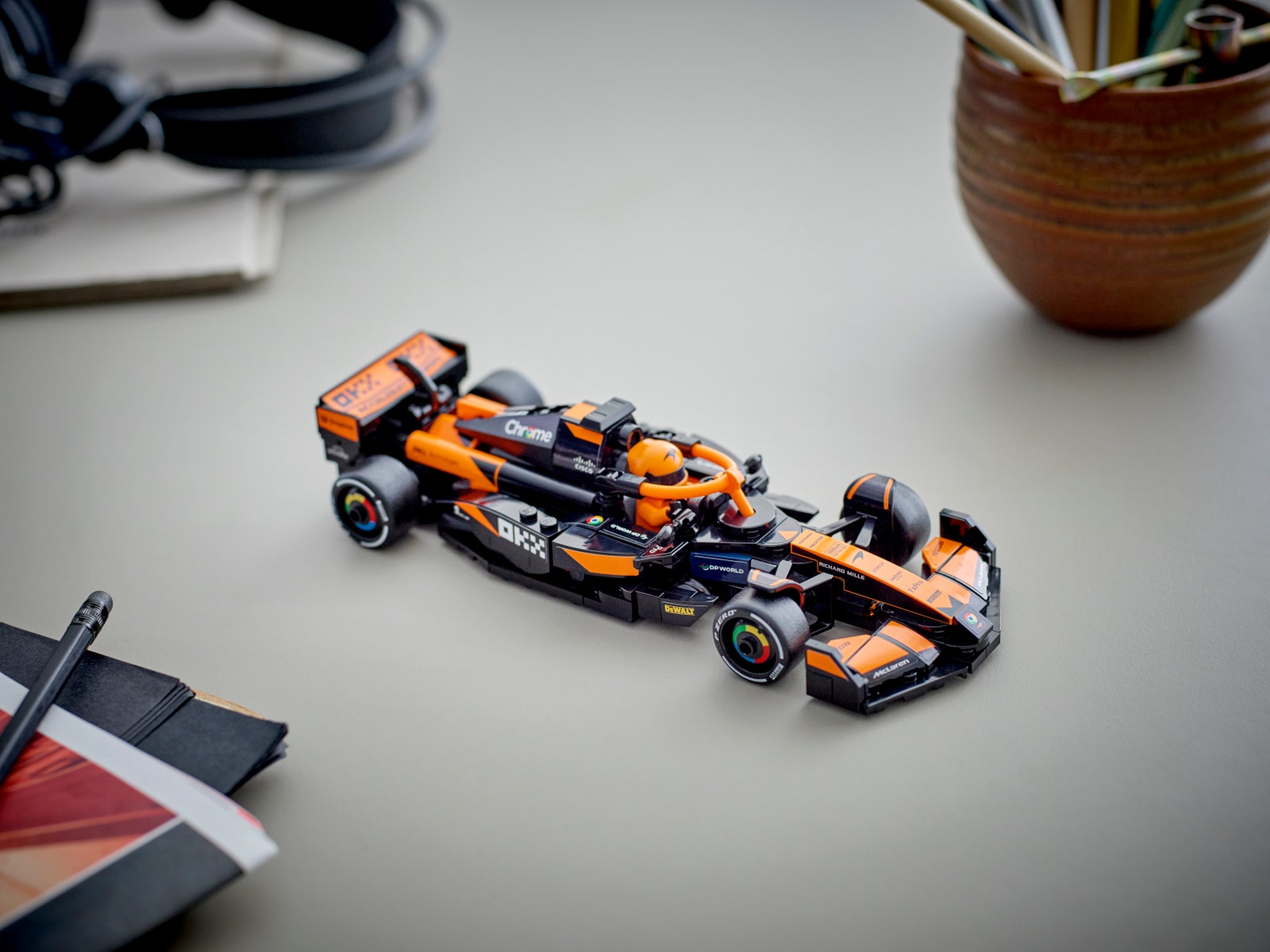 A small orange and black racing car built with Lego blocks that imitate a Formula 1 car model.