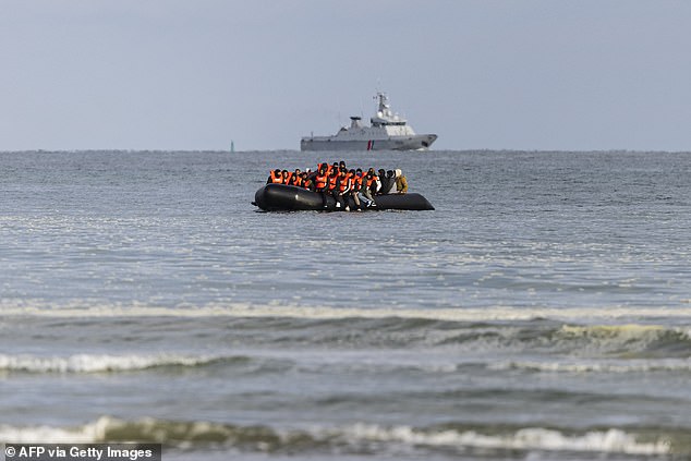 Migrants board a smuggling boat in an attempt to cross the English Channel, at Gravelines beach, near Dunkirk, northern France.