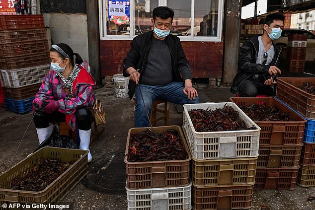 This photo taken on April 15, 2020 shows vendors wearing face masks as they offer prawns for sale at Wuhan Baishazhou Market in Wuhan, central China's Hubei Province.