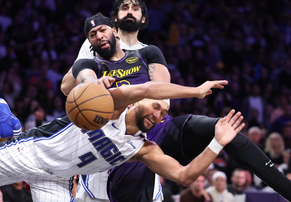 Lakers forward Anthony Davis and Orlando's Jalen Suggs, forward, battle for a rebound in the fourth quarter Thursday.