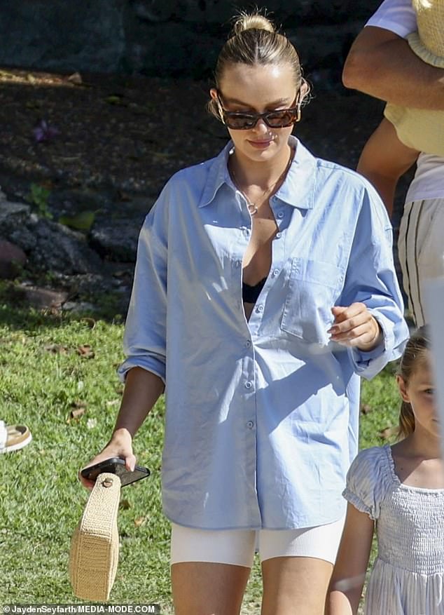 She added a pair of white shorts along with sandals in the same tone, carrying a branded bag.