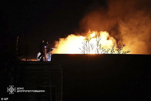 Rescue workers extinguish a fire in a building badly damaged by a Russian attack on Dnipro, Ukraine