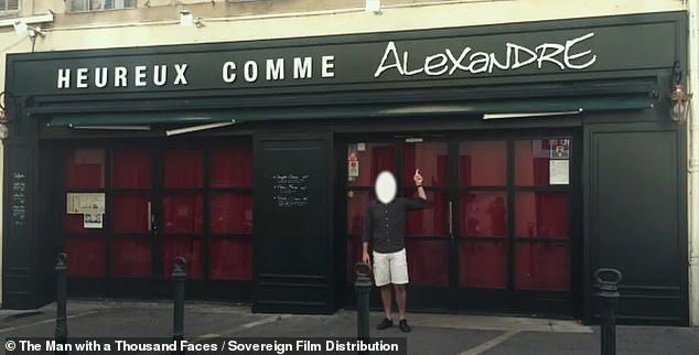 The man poses next to the window of a restaurant that had his false name