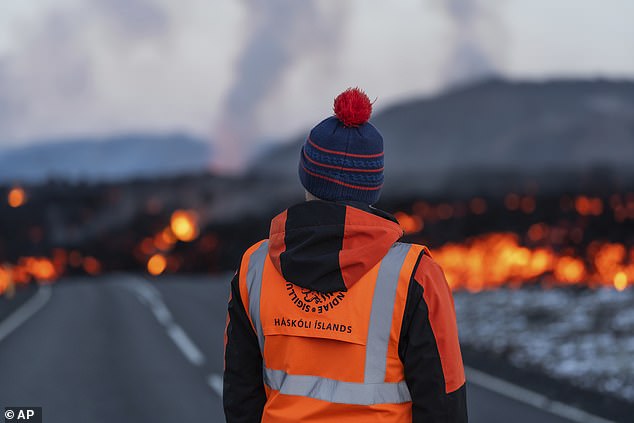 A University of Iceland scientist observes the lava flow Thursday morning