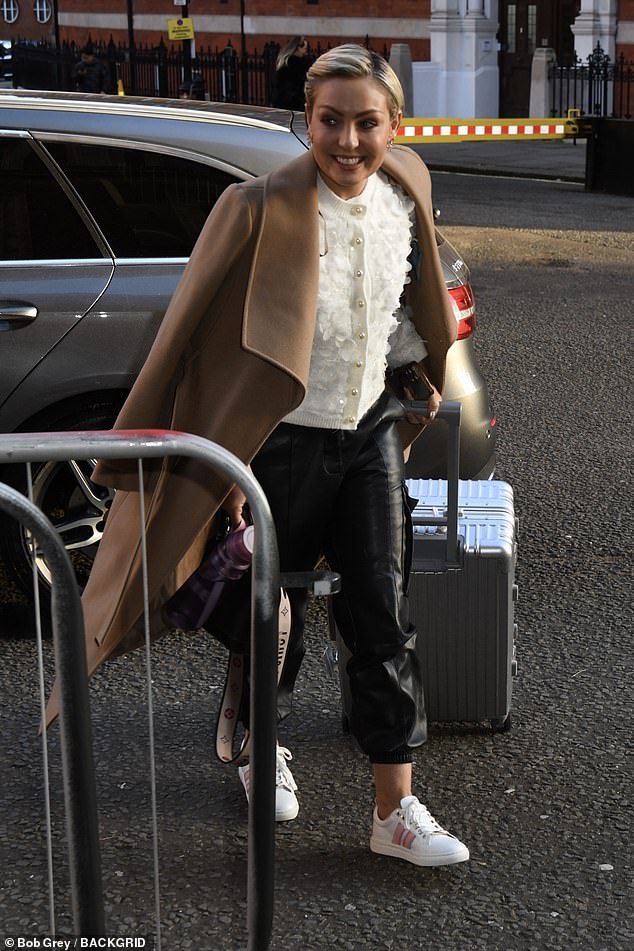 Amy wore the jacket over a cream cardigan and black pants with white sneakers.