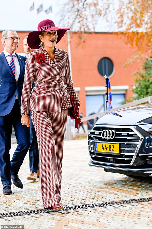 Maxima accessorized the ensemble with a pair of sophisticated red leather gloves and heeled boots in a matching deep red hue.