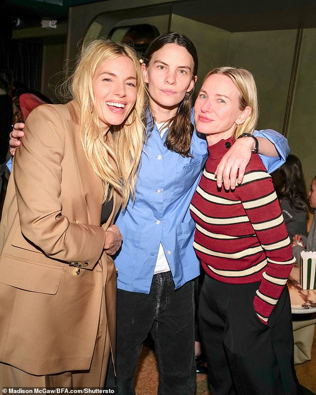 Meanwhile, Naomi Watts (right) looked comfortable in a red and white striped sweater as she posed alongside Sienna and Eliot Sumner (center).