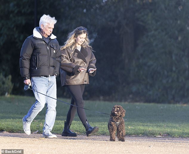 Molly dressed in a stylish brown coat and boots, while accessorizing with dark sunglasses.