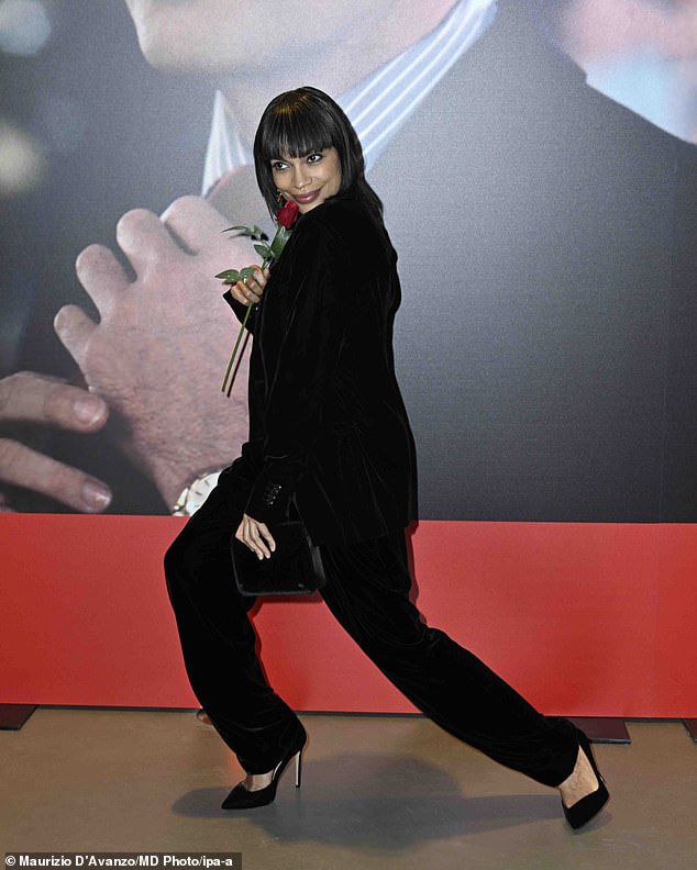 She paired the chic blouse with a black velvet jacket and matching pants as she posed up a storm at the event.