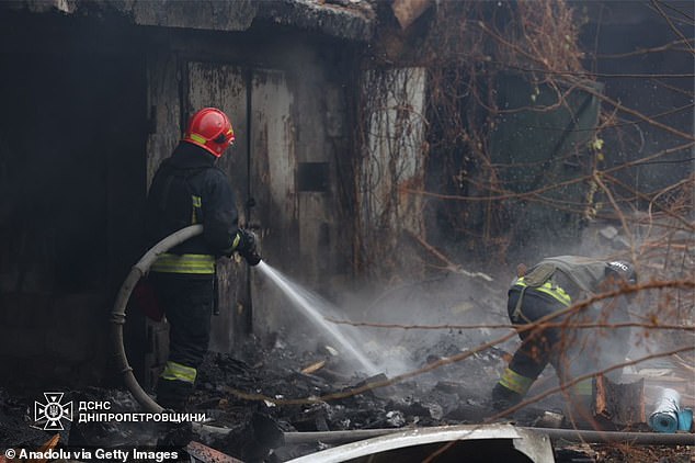 Firefighters work at the site of the Russian missile attack in Dnipro