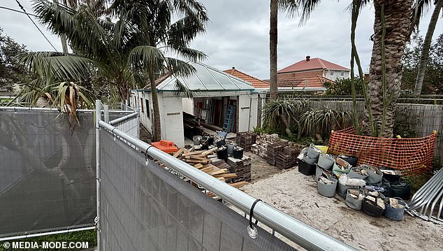 The roof and windows have been demolished, with tiles and building material piled up at the rear of the property.