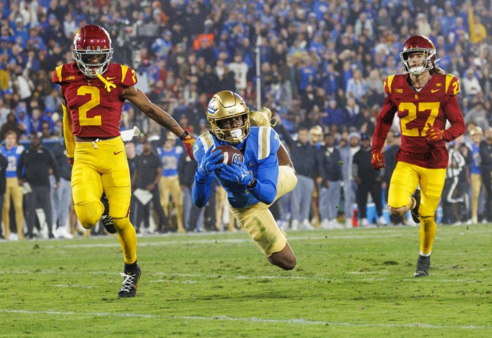 UCLA receiver J.Michael Sturdivant catches a long pass between USC cornerback Jaylin Smith and safety Bryson Shaw.