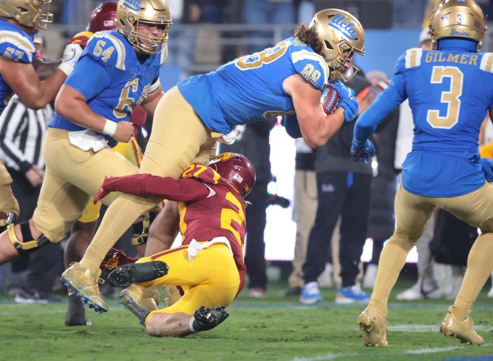 UCLA tight end Moliki Matavao beats USC safety Bryson Shaw to reach the end zone in the third quarter in the Rose Bowl.