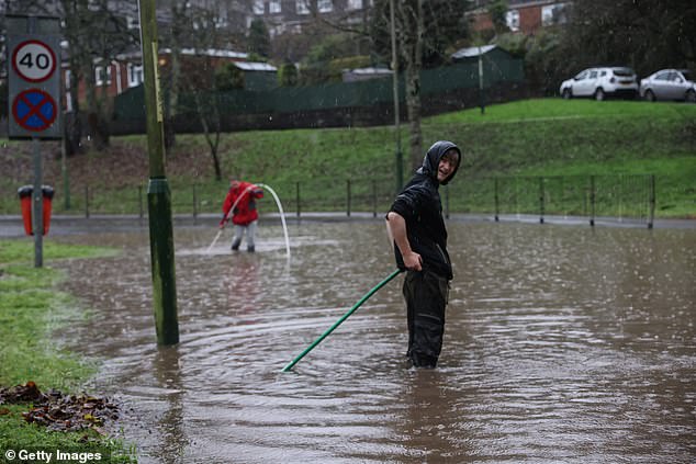 Residents try to clear drains to allow water to go down in Abercarn, Newport