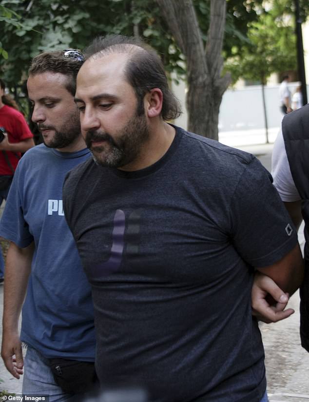 Mokbel is escorted by police officers after appearing in court on June 8, 2007 in Athens, Greece. He had fled Australia after being told he was about to be charged with murder.