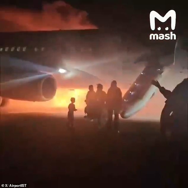 Dramatic images show dozens of passengers, including children, fleeing the burning plane as sirens blare in the background.