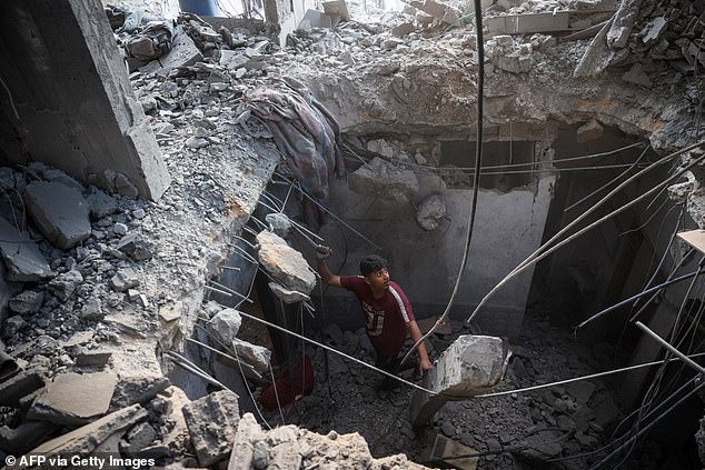 A Palestinian inspects the rubble of a house that was destroyed in an Israeli strike in the Bureij refugee camp in the central Gaza Strip on November 24, 2024.