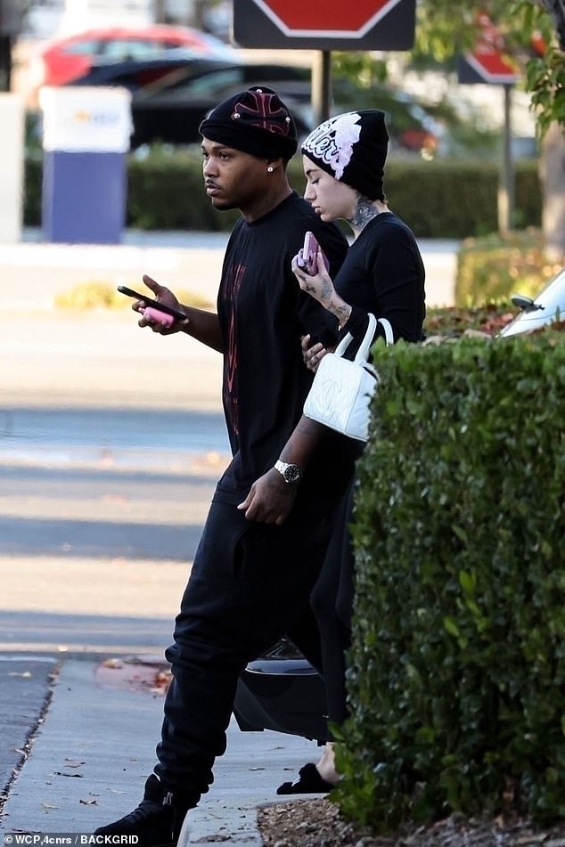 She accessorized her casual ensemble with a beanie with graffiti letters scrawled on the front, a white quilted bag, and fuzzy slippers.