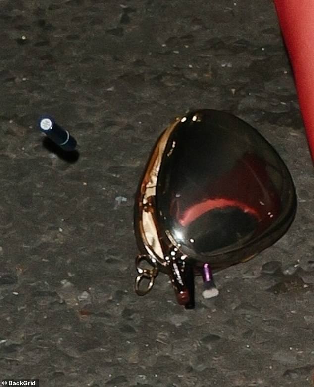 Jess's metallic heart-shaped purse fell off its strap and crashed to the ground while its contents, including her makeup, fell out and were dumped across the street.