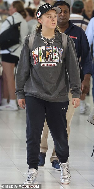 He got into the festive spirit early in the trip as he wore a gray 'Merry Christmas' sweater with a variety of popular movie characters printed on it.