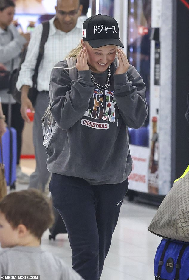 The singer packed her essentials into a gray backpack and flashed a big smile as she looked delighted to have landed in Australia.