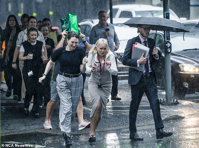 How added that much of the country could meet and even exceed November's monthly rainfall average by Friday night (pictured, CBD workers in Brisbane dodging the rain)