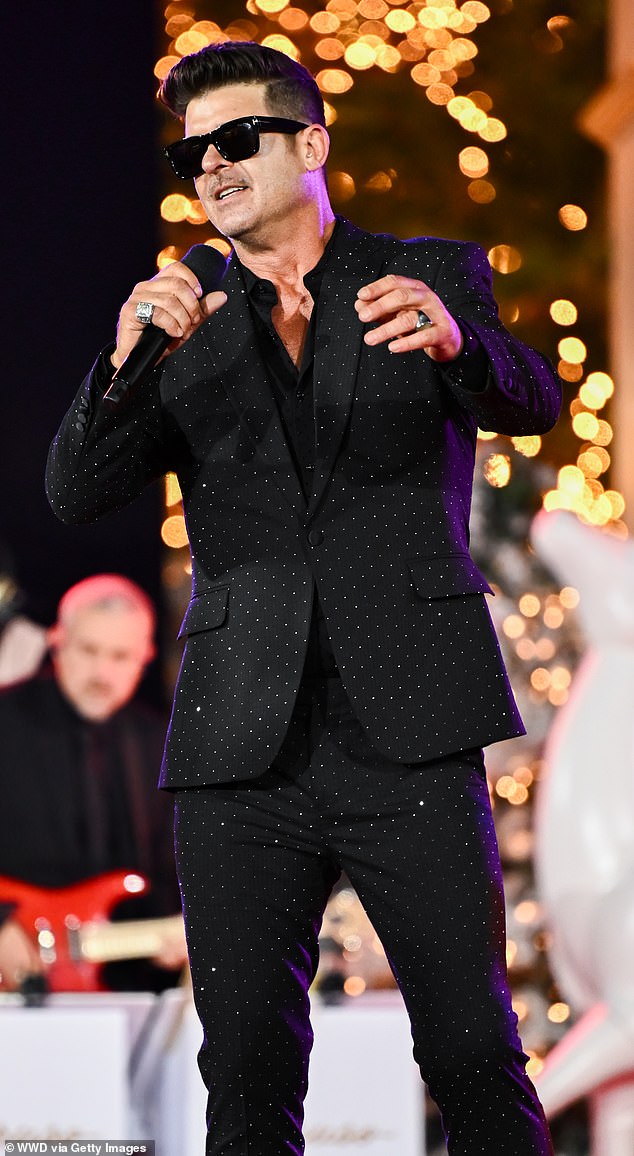 The veteran music artist posed for red carpet photos in a pair of shiny black sunglasses before taking the stage to sing.