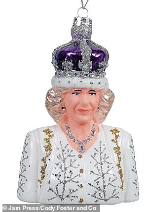 For Camilla, Queen Consort, the figure wears a purple crown, a white Christmas-themed dress, and a sparkling diamond necklace.