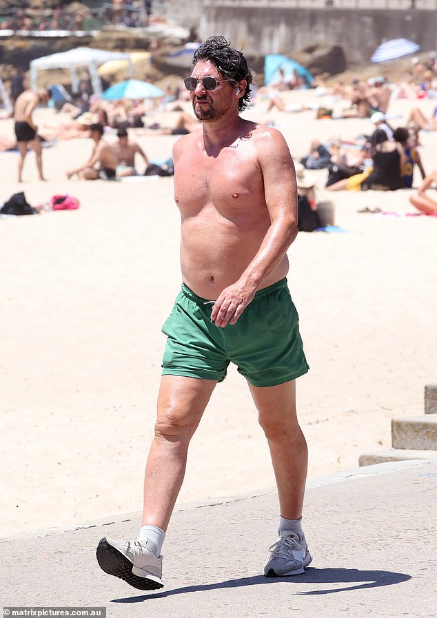 The 51-year-old walked shirtless wearing a revealing green and white swimsuit.