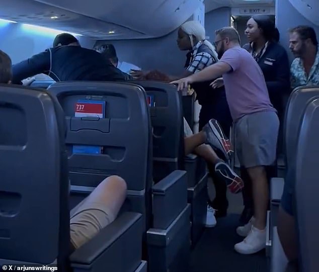 Passengers were seen shouting at him to take his hands off the woman sitting next to him while a flight attendant tried to mediate.