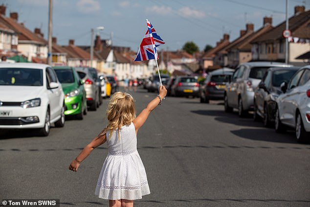 Four-year-old Poppie Stacey is seen waving a Union flag during the 75th anniversary celebrations marking VE Day in May 2020.