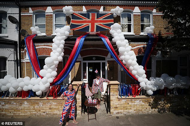 Pictured are Jane and Toby Lyde outside their home in Tooting on the 75th anniversary of VE Day, London 2020.