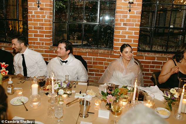 The bride and her new husband, Jake, wore clear plastic raincoats to their wedding dinner to avoid getting food on their clothes.