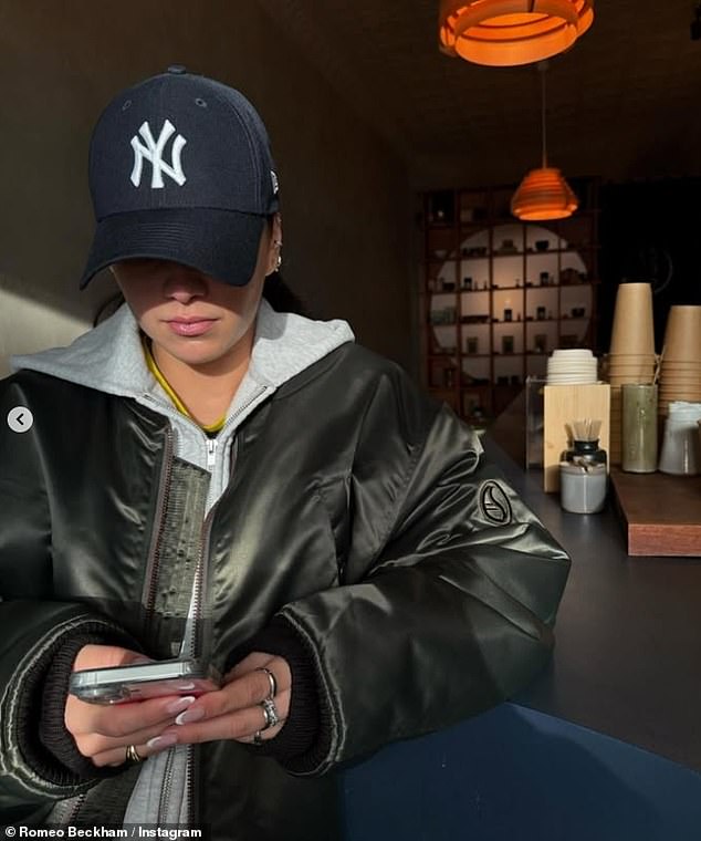 In another snap, Romeo shared a candid photo of Kim playing on her phone in the same cafe while bundled up in a leather jacket and blue cap.