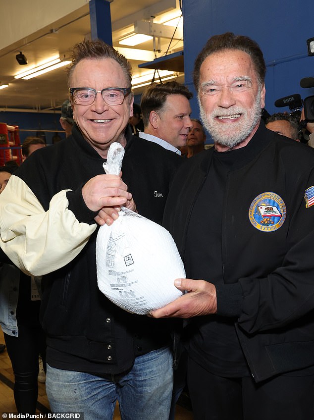 Arnold rocked a casual all-black look for the pre-holiday festivities, showing off his patriotism in a black bomber jacket with an American flag patch on one sleeve and a California flag on the other.