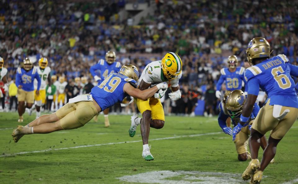 UCLA linebacker Carson Schwesinger jumps toward Oregon wide receiver Traeshon Holden while running for a touchdown on Sept. 28.