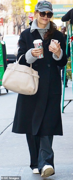 Spotted walking to work on Thursday, Katie showed off her winning street style, draping a sleek black coat over a sweater with an extravagant collar.