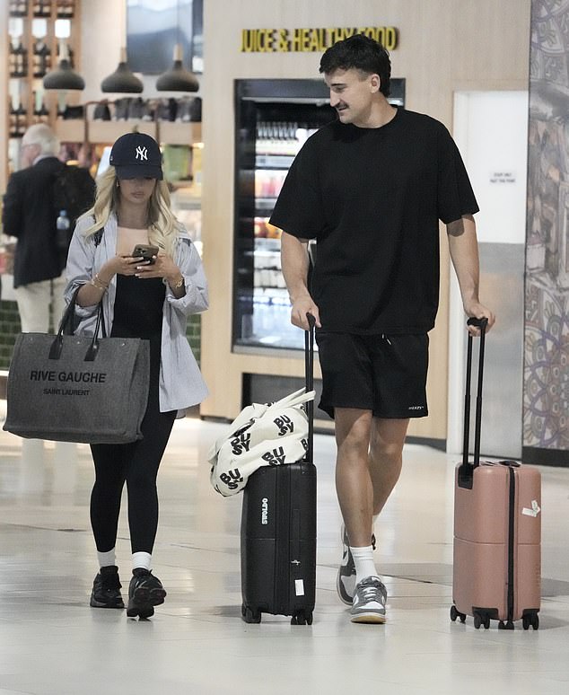 Ivan cut an equally relaxed figure in black shorts and a dark t-shirt as he dragged several large suitcases behind him.