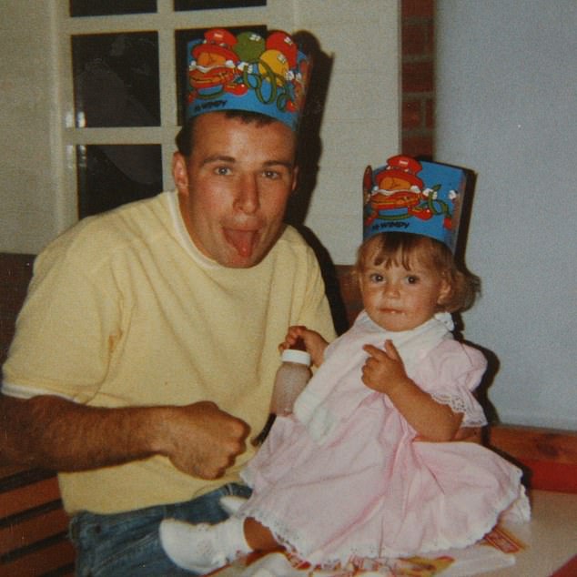 Little Coleen wearing a paper hat while posing with her dad.