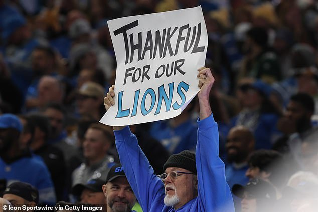 A Lions fan holds up a homemade sign ahead of the 2023 Thanksgiving game against the Packers