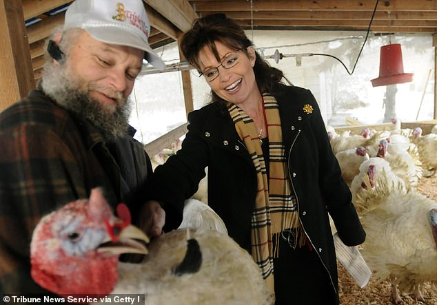 Anthony Schmidt (left), owner of Triple D Farm and Hatchery, holds the turkey that was pardoned by Alaska Governor Sarah Palin