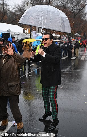 The Tonight Show star had viewers in stitches as he wore black sunglasses despite standing under an umbrella in the pouring rain