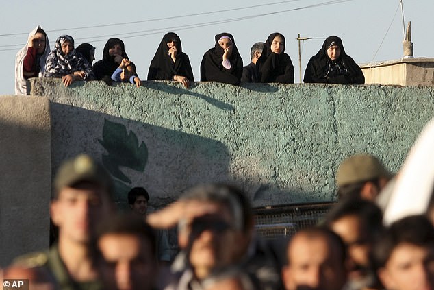 Under Iran's sharia law, a victim's family can ask for blood money to spare the perpetrator's life or also decide to forgive. In the image: Locals watch the hanging take place.