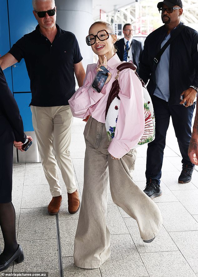 Ariana came dressed to impress for her flight, flaunting a boho chic vibe in a pair of off-white flared pants. She accessorized with a pair of large, square-framed glasses that further eclipsed her already small face.