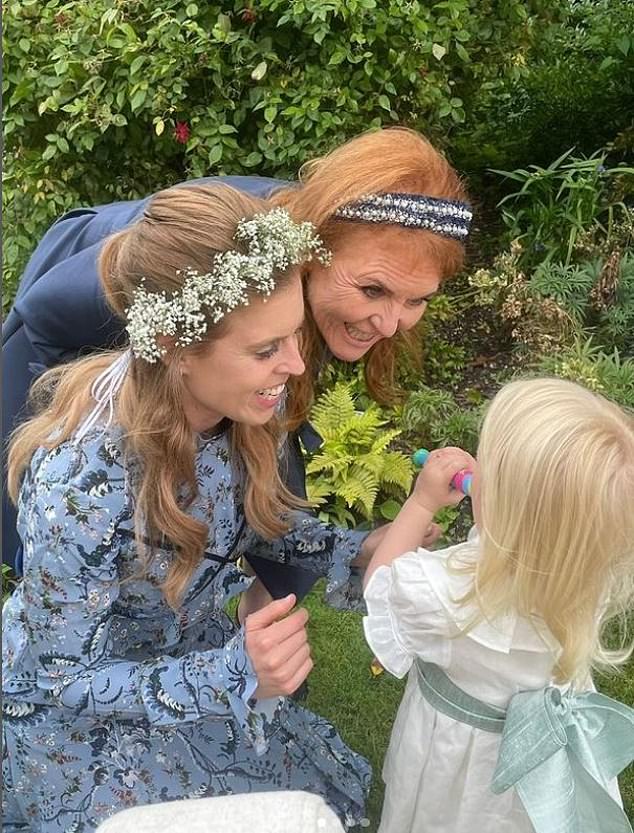 Sarah and Beatrice smiling at the princesses' daughter, Sienna.