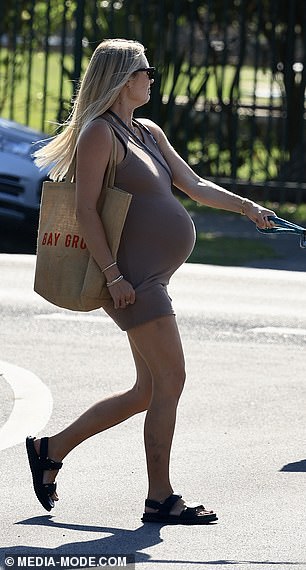 For the outing, Elyse looked chic in an olive sleeveless dress that cradled her baby bump.