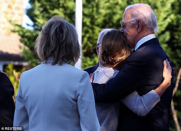 President Joe Biden (right) hugs Hallie Biden (center), Beau Biden's widow who briefly dated Hunter Biden after her husband's death in 2015.