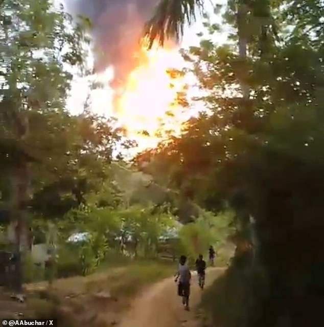 Residents run as flames from the volcano shoot into the sky.