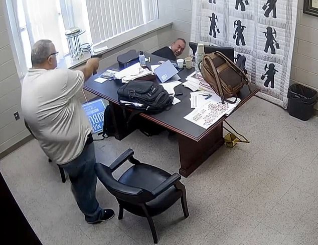 The judge can be seen trying to take cover behind his desk as Stines points his gun at him.