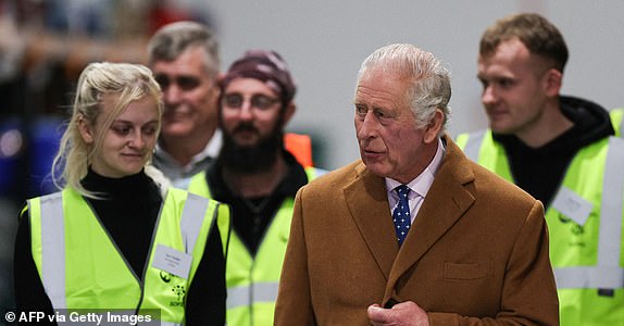 Britain's King Charles III (C) talks to members of staff as they watch Fairshare food vans being loaded with produce for distribution during the launch of "The coronation food project"to mark Her Majesty's 75th birthday, as part of a visit to the South Oxfordshire Food and Education Alliance, part of the FareShare network, in Didcot, west of England, on November 14, 2023. The Food Project Coronation Day, inspired by The King, and Coordinated by The Prince of Wales's Charitable Trust, seeks to close the gap between food waste and food need across all four nations of the United Kingdom, helping people and helping the planet. (Photo by Adrian DENNIS/AFP) (Photo by ADRIAN DENNIS/AFP via Getty Images)